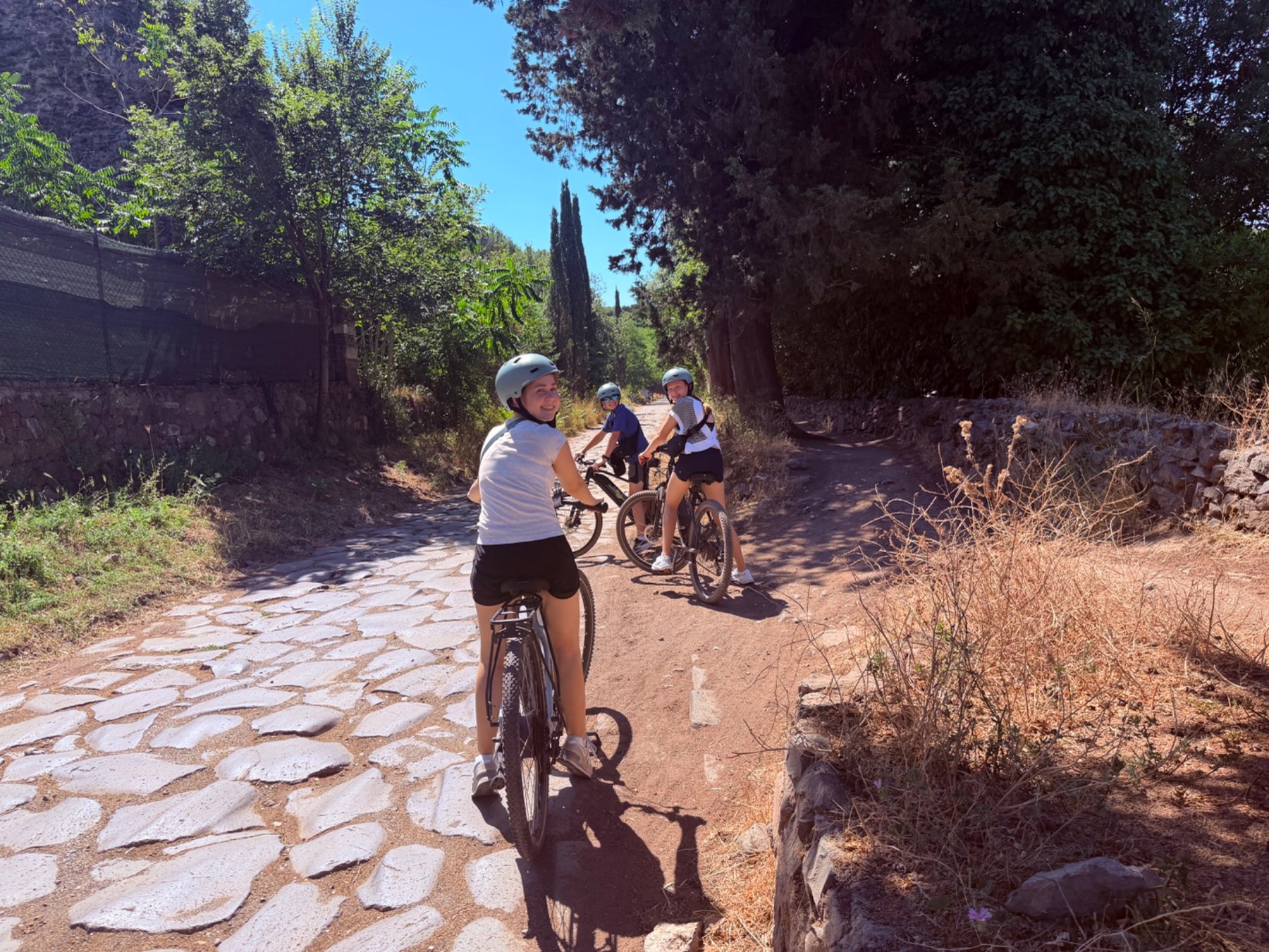 Kim's family riding e-bikes on an ancient stone road near Rome